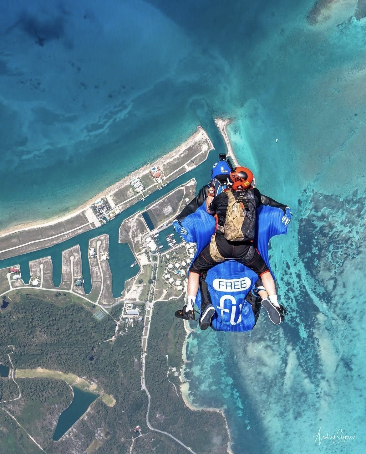 A skydiver in freefall over the marinas and reef of West End, Grand Bahama