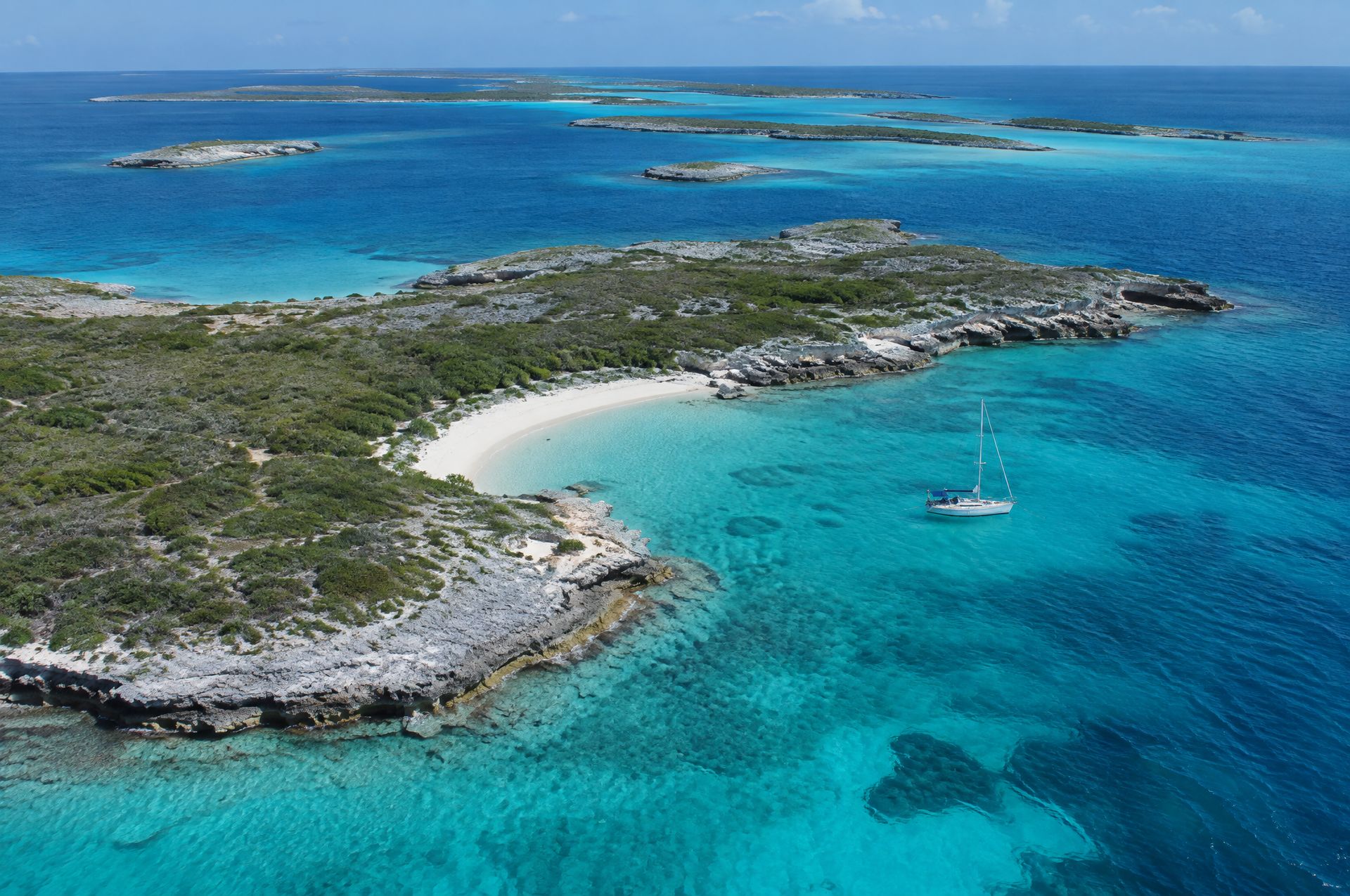 A rocky cay and an anchored sailboat in the Exuma Cays Land and Sea Park