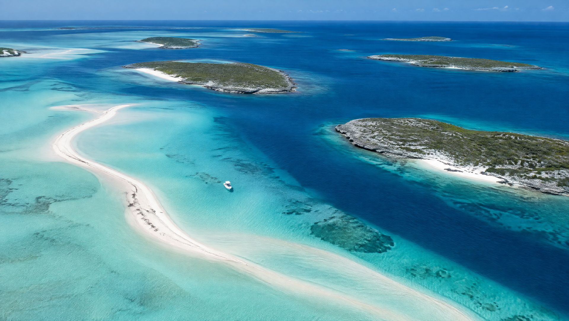 A white sandbar winding through turquoise shallows in the Exuma Cays