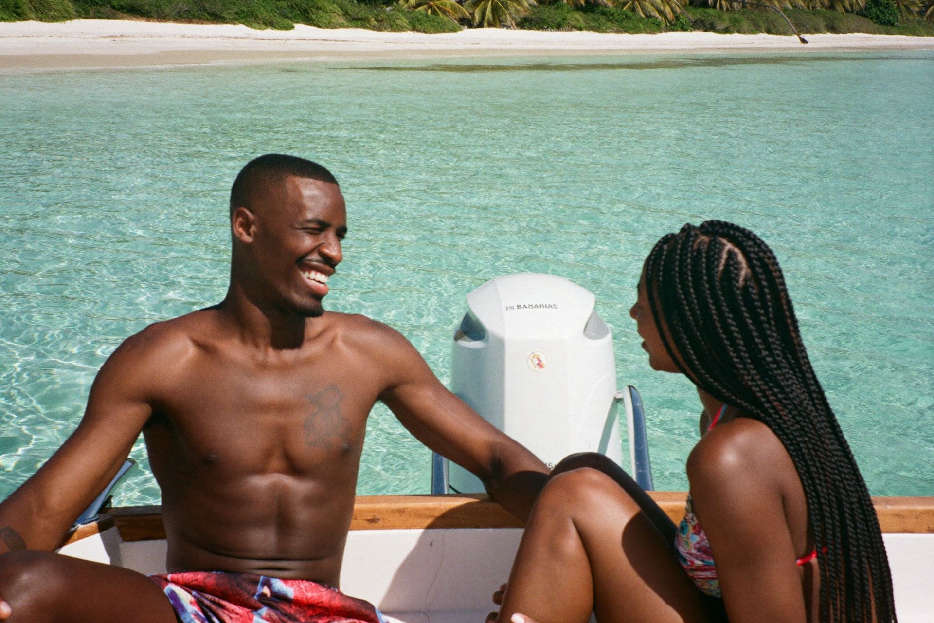 A couple on a private boat off the Rose Island sandbar