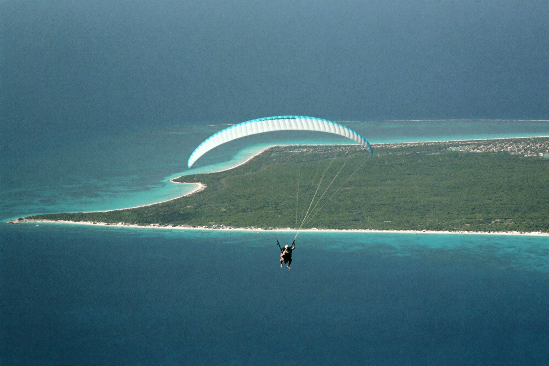 A tandem paraglider above Rose Island