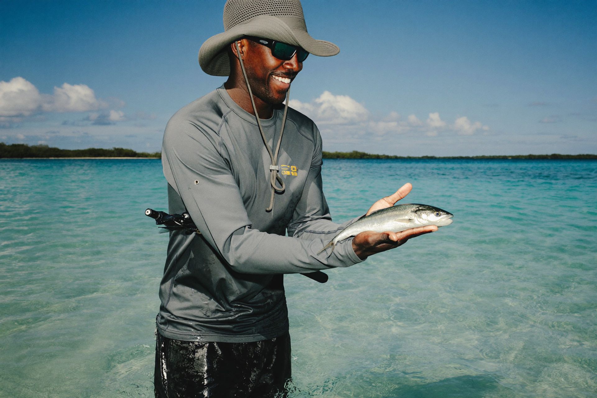 A bonefishing guide holding a bonefish on the flats of Andros