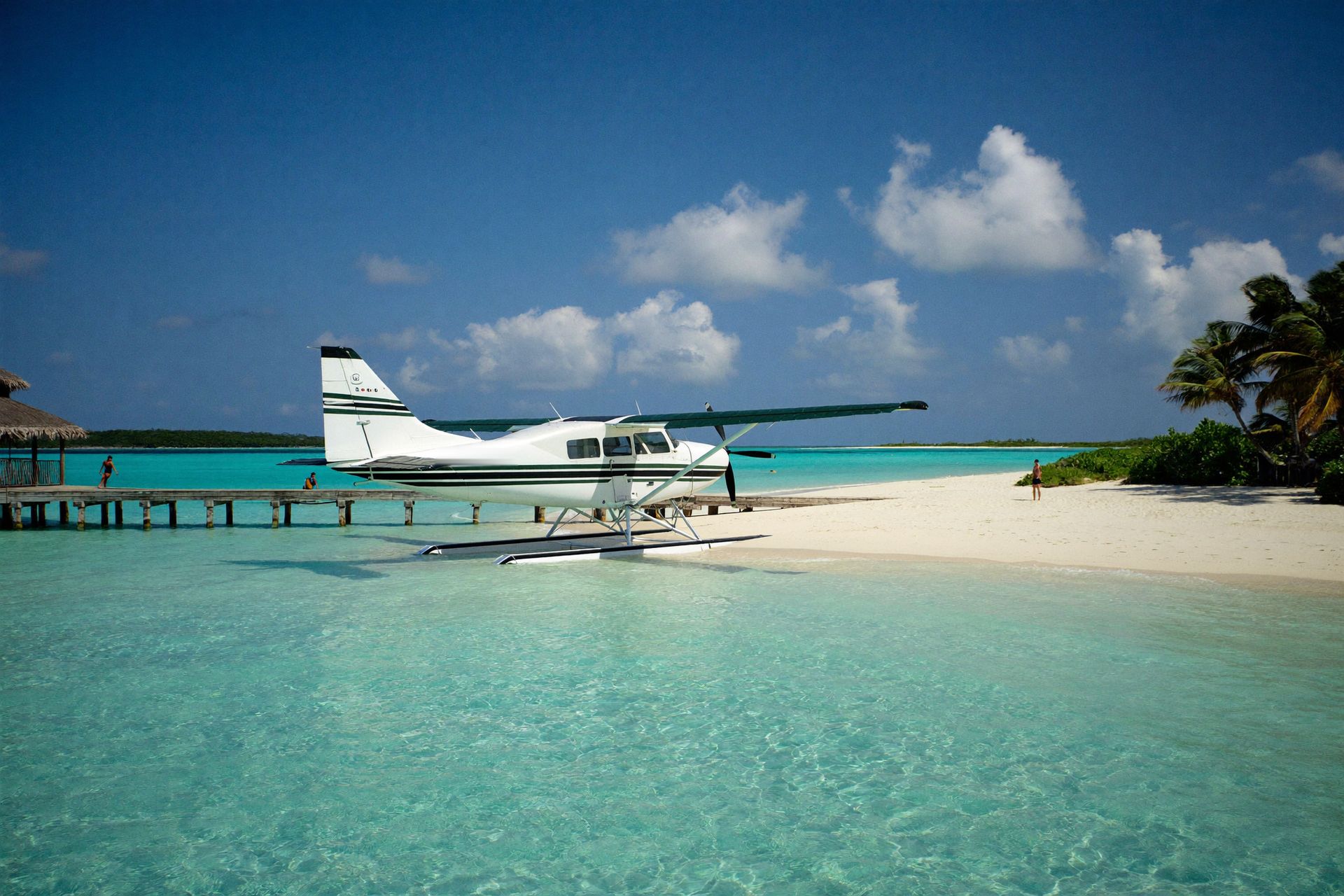 A seaplane moored off a white-sand out-island beach