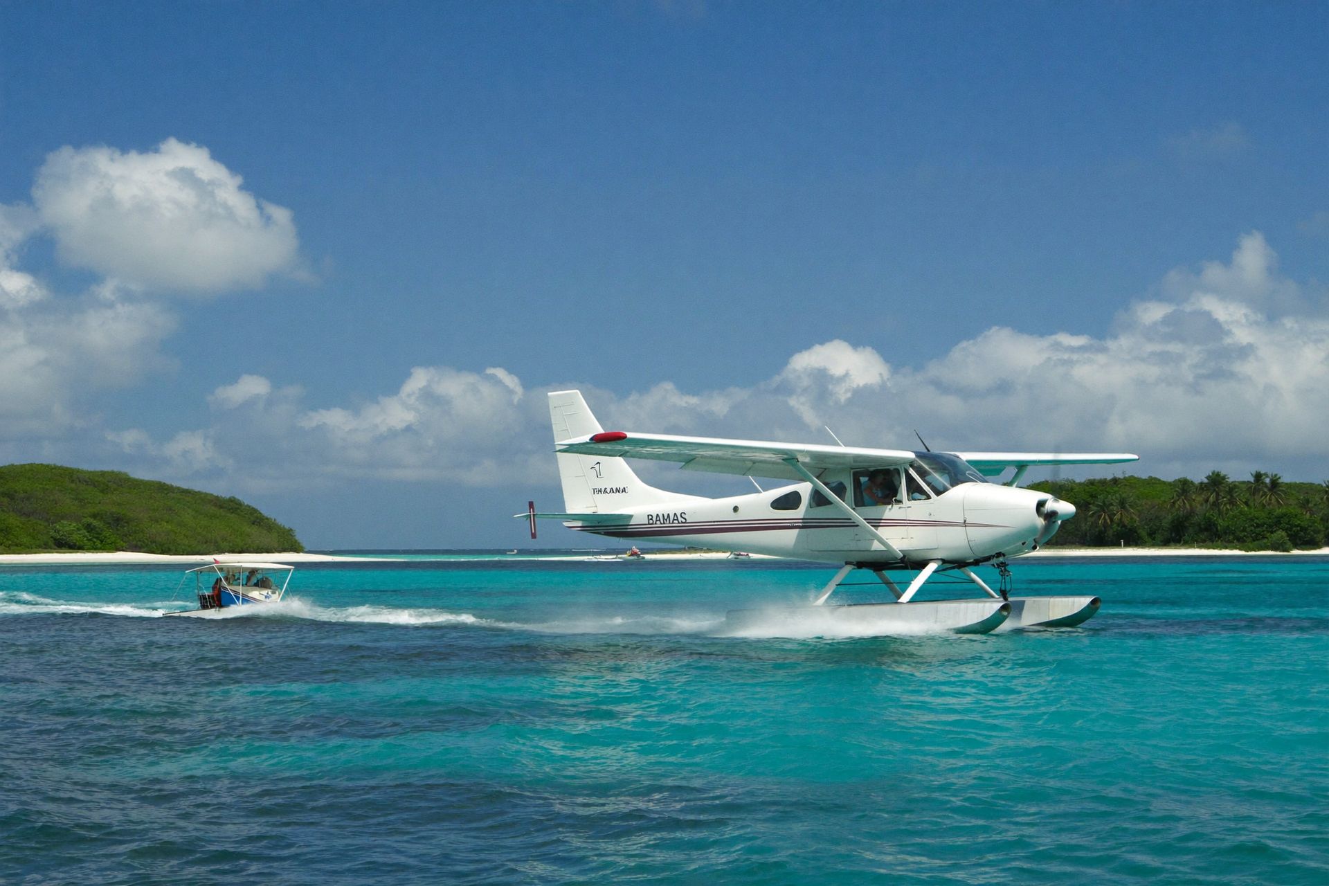 A seaplane landing beside a small cay